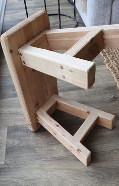 a chair made out of wood sitting on top of a hard wood floor next to a rug