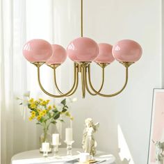 a pink chandelier hanging over a dining room table