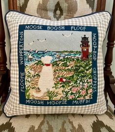 a cross stitch pillow sitting on top of a chair