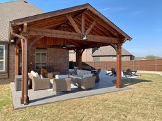 an outdoor covered patio with furniture and grill