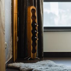 a wooden rack with five pairs of shoes on it in front of a curtained window