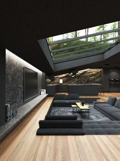 a modern living room with wood floors and black furniture in the center, along with skylights