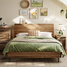 a bed with green sheets and pillows in a bedroom next to a dresser, lamp and pictures on the wall