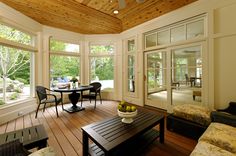 a living room filled with furniture and windows covered in wood planks on top of a hard wood floor