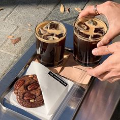 two glasses of iced coffee and a chocolate cookie on a tray