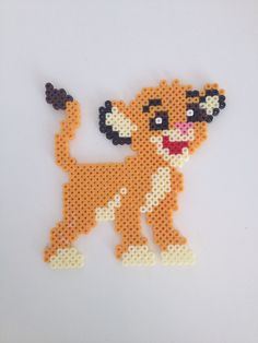 an orange and white beaded animal with black spots on it's face, standing in front of a white background