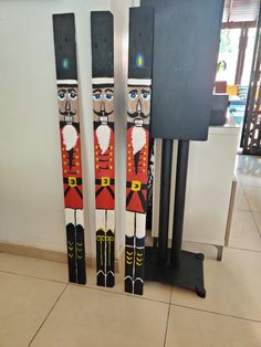 three skis are standing next to each other in front of a speaker on the floor