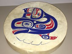 a blue, red and white plate with an image of a bird on it's face