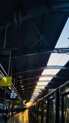 an empty train station with people standing on the platform