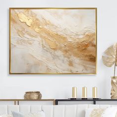 a living room with white couches and gold accents on the wall above it is a large abstract painting