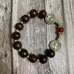 Crafted using green cypress wood, gemstones, stretch cord, and a delicate Miraculous Medal, this Catholic bracelet measures 7 inches in length. Black natural wood Catholic Bracelet with red gemstone beads, Catholic Gift, Holy Bracelet,Praying Bracelet,Wood Bracelet, Nativity Bracelet ➡️ NOTE: - Please note that the final product may vary slightly in color or wood grain compared to what is depicted in the photos. This can be due to factors such as the unique characteristics of the wood, the quali Spiritual Stretch Bracelet With Wooden Beads For Meditation, Spiritual Wooden Beads Stretch Bracelet For Meditation, Spiritual Rosary Bracelet With Wooden Beads, Spiritual Brown Bracelets With Wooden Beads, Spiritual Wood Round Beads Jewelry, Traditional Wooden Bracelets As A Gift, Traditional Wooden Bracelet As Gift, Spiritual Wooden Beads Stretch Bracelet For Healing, Spiritual Wooden Beaded Bracelets