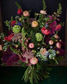 a vase filled with lots of different colored flowers