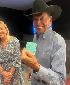 two people standing next to each other wearing cowboy hats and holding up a note that says no you