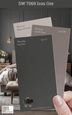 a person holding up two shades of gray in front of a bedroom with the words sw 709 iron one on it