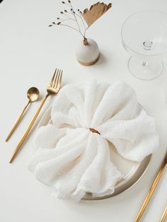 a white plate topped with napkins and gold forks