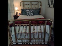 a bed with gold metal frame and red bedspread