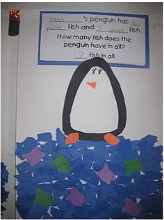 a bulletin board with a penguin and fish on it's back side, in front of a white wall