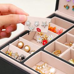 a person holding an open jewelry box