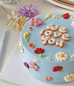 a blue cake decorated with flowers and the word love on it