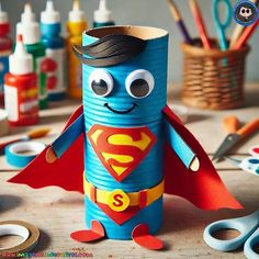 a toilet paper roll with a superman character on it, surrounded by crafting supplies