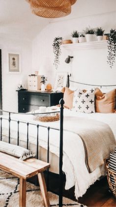 a bed room with a neatly made bed next to a wooden table and dressers