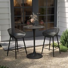 two chairs sitting at a table with wine glasses on it