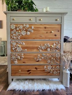 an old dresser has been decorated with flowers and gold leafy decorations on the drawers