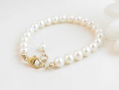 "A classic real freshwater pearl bracelet for newborn, infant, baby, child, little girl, tween or teen. This keepsake bracelet is created with Grade-A 5.5mm round freshwater pearls and a 14K gold-filled oval lobster clasp with a 1/2\" \"Grow with Me\" extender chain. Arrives packaged in my signature high-quality reusable canvas gift bag. Beautiful and ready for gift giving. S I Z I N G . G U I D E The bracelet should be 3/4\" larger than her snug wrist measurement. If you are unable to measure, Classic Pearl Bracelet With Extender For Gift, Elegant Pearl Rosary Bracelet For Baptism, Elegant Pearl Jewelry For Baptism, Classic Beaded Bracelet With Extender As Gift, Classic Adjustable Pearl White Bracelet, Elegant Pearl White Jewelry For Baptism, Elegant Adjustable Pearl Bracelet For Baptism, White Hypoallergenic Pearl Bracelet For First Communion, Classic Adjustable Jewelry For First Communion