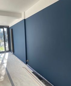 an empty room with blue walls and windows