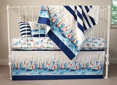 a white crib with blue and red sailboats on it