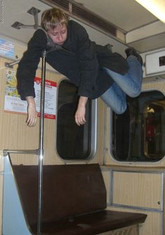 a man is jumping off the side of a train with his legs in the air