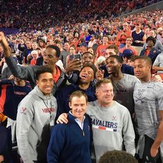 a group of men standing next to each other in front of a crowd