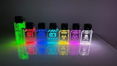 an assortment of different colored lighters sitting next to each other on a reflective surface