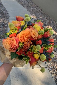 a bouquet of flowers sitting on top of a cement bench next to gravel and rocks