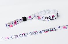 two white lanyards with flowers on them and the words your text here printed on them