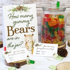 gummy bears are in the jar next to a sign and some pineconis