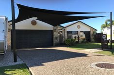 a house with a black awning in front of it and a white trailer parked next to it