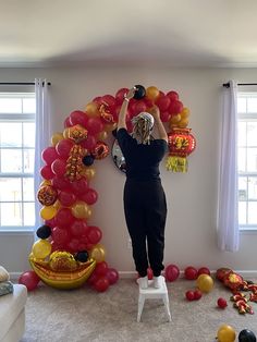 a woman standing in front of a balloon arch