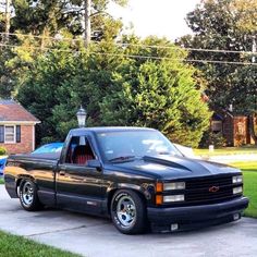 a black truck parked in front of a house