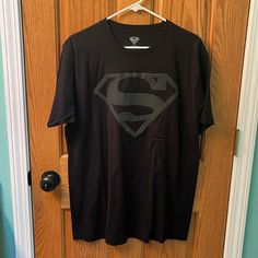 a t - shirt with a superman symbol on it hanging from a door hanger