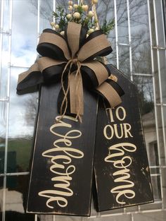 two wooden signs with the words welcome and to our wedding hanging on a door hanger