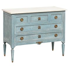 an old blue dresser with marble top and brass knobs on the drawers, isolated against a white background