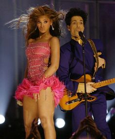 the singer and dancer are performing on stage with their guitars in hand as they look at each other