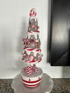 a three tiered cake decorated with candy canes and candies on a plate