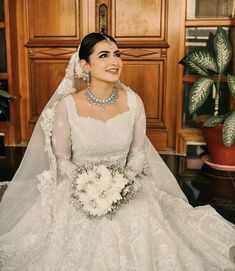 a woman in a wedding dress sitting on the floor