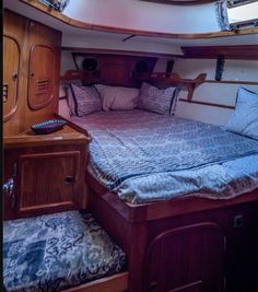 the inside of a sailboat with a bed and pillows on it's side