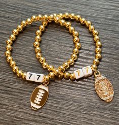 What better way to represent your favorite player than with a customized number bracelet!   Beads are 5mm and gold filled  Choices for customization include  *Black or Gold Font Numbers  *Sparkle or Flat Sports Charm Bracelets can be either elastic or lobster clasp closure with 2" extender. please specify in Notes to Seller Listing is for 1 bracelet Adjustable Gold Beaded Bracelets For Game Day, Gold Charm Bracelet With Letter Beads For Friendship, Gold Letter Beads Charm Bracelet For Friendship, Gold Beaded Bracelets With 8mm Beads For Birthday, Gold Beaded Bracelets With Charms And Round Beads, Customizable Gold Beaded Bracelets For Birthday, Gold Beaded Bracelets With Charms For Friendship, Customized Gold Stretch Bracelet For Birthday, Customizable Gold Stretch Bracelet For Birthday