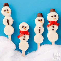 four snowman pops are sitting in the snow