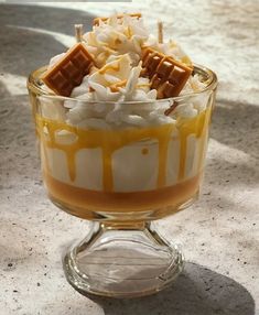 a dessert in a glass dish with marshmallows and caramel sauce on top