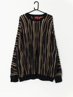 Vintage Coogi style sweater with bold gold stripes. This beautiful sweater has a 3D knitted effect, in black and gold. This coogi sweater is perfect all year round and will look great will everything! The sweater is made from a soft, mid-weight cotton. By J. Simon.  Our recommended size: Large to XL Label says: 2XL / 2TG Condition: Very good  Material: 100% cotton Measurements in inches: Pit to pit: 25.5 Shoulders: 27 Front length: 31.5 Back length: 30.5 Sleeve length: 24 Hem unstretched: 20 Hem Winter Striped Jacquard Knit Sweater, Winter Jacquard Knit Striped Sweater, Striped Jacquard Knit Sweater For Winter, Gold Knit Winter Sweater, Gold Knit Sweater For Winter, Gold Long Sleeve Sweater, Gold Crew Neck Sweater For Fall, Coogi Sweater, Pullover Sweater Men